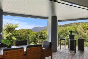 a bedroom with a view of the mountains through a large window at Tarawera Paradise in Rotorua