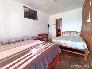 a bedroom with two beds with towels on them at El Paraíso in Huarmey