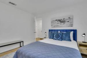 um quarto com uma cama azul com almofadas azuis em Statesboro Luxe: Luxury In A Prime Location em Statesboro