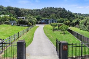 a driveway leading to a house with a fence at Tarawera Paradise in Rotorua