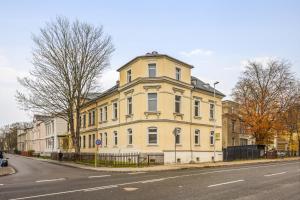 un grand bâtiment jaune sur le côté d'une rue dans l'établissement YourFavoriteBed - Moderne Monteurwohnungen in Zwickau, à Zwickau