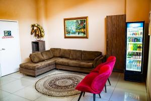 a living room with a couch and two red chairs at Dom Quixote São Gonçalo Hotel in São Gonçalo