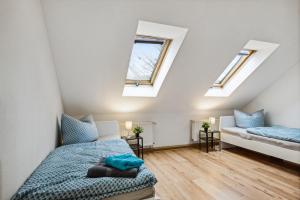 a attic bedroom with two beds and skylights at YourFavoriteBed - Moderne Monteurwohnungen in Zwickau in Zwickau