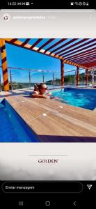 una foto de una persona en una piscina en Golden Laghetto Gamado en Gramado