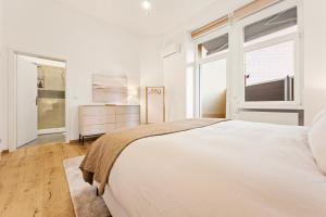 una camera da letto bianca con un letto grande e una finestra di Castillo Grande a Ludwigshafen am Rhein