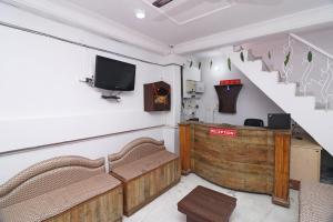 a living room with a staircase and a tv at OYO Hotel Chandrabhaga in Rishīkesh