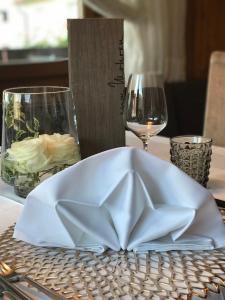 a white napkin on a table with wine glasses at Hotel Zum Mohren in Tesimo