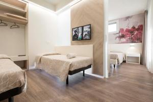 a bedroom with two beds and a table at Hotel Harmony in Rimini