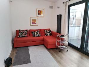 um sofá vermelho numa sala de estar com uma janela em Cosy Home near Central London E1 em Londres