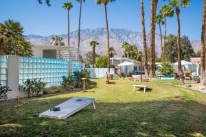 un parque infantil con cama elástica en un patio con palmeras en The Monkey Tree Hotel Buyout by AvantStay Entire Hotel Buyout Funky Rooms w Modern Amenities en Palm Springs