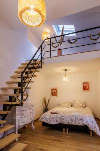 a bedroom with a bed and a staircase at L isle aux rêves Nid douillet au cœur de ville in L'Isle-sur-la-Sorgue