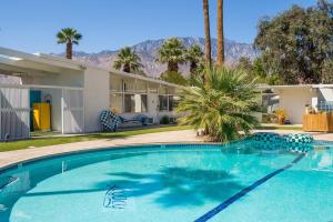 una piscina frente a una casa en The Monkey Tree Hotel Buyout by AvantStay Entire Hotel Buyout Funky Rooms w Modern Amenities en Palm Springs