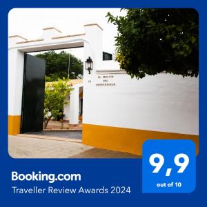 a door to a house with the text travelling review awards at El Molino del Huertezuelo in La Palma del Condado