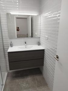 a white bathroom with a sink and a mirror at Casa Elai in Sant Carles de la Ràpita