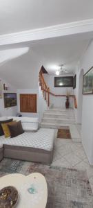 a living room with a couch and a staircase at Marbi Guest House in Gjirokastër