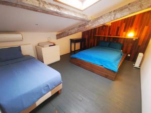 a bedroom with two beds with blue sheets and wooden walls at home, sweet home in Vitry-sur-Seine