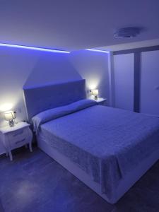 a bedroom with a large bed with a blue light at Casa Elai in Sant Carles de la Ràpita