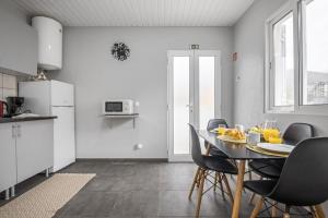uma cozinha e sala de jantar com mesa e cadeiras em The Blue House no Funchal