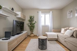 uma sala de estar com um sofá e uma televisão em The Blue House no Funchal