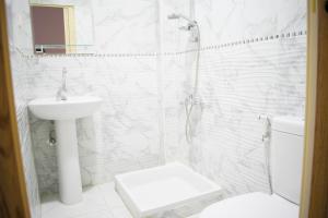 La salle de bains blanche est pourvue de toilettes et d'un lavabo. dans l'établissement golden palace down town, au Caire