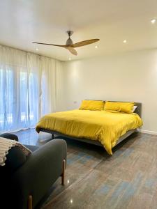 a bedroom with a yellow bed with a ceiling fan at Spacious Resort Getaway @ Echo Park Ranch - Luxury indoor/ outdoor home steps from Sunset Blvd, Echo Park Lake, Dodgers Stadium in Los Angeles