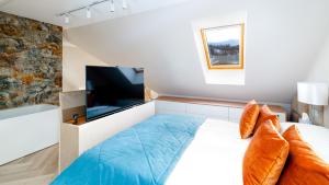a bedroom with a large bed and a flat screen tv at Komfortowy Apartament LOTOS z sauną i widokiem na Śnieżkę in Karpacz