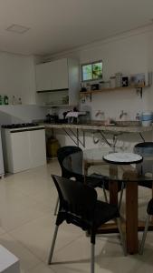 倫索伊斯的住宿－Estadia Fox，厨房配有玻璃桌和椅子