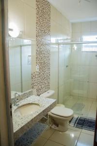 ein Bad mit einem WC, einem Waschbecken und einer Dusche in der Unterkunft Rancho para Temporada,Três Marias mg. in Três Marias