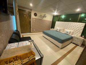 Habitación pequeña con cama y ducha en Fusion Lodge, en Islamabad