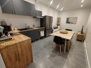 a kitchen with a wooden table and a kitchen with a dining room at Le Refuge des Voyageurs in Conflans-sur-Seine