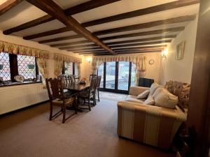 een woonkamer met een bank en een tafel bij Grace Dieu Cottage - Sleeps 7 in Whitwick