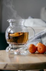 un pot en verre rempli de thé et d'oranges sur une table dans l'établissement Wysoka Trawa Gruszków, à Kowary