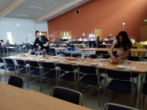 two people standing around a table in a restaurant at Godaland Guesthouse in Hlíðarendi