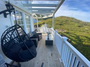 un porche con un columpio en una casa en Villa Stø in Vesterålen (Lofoten) Norway, en Stø