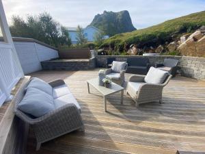 un patio con sillas de mimbre y una mesa en una terraza. en Villa Stø in Vesterålen (Lofoten) Norway, en Stø