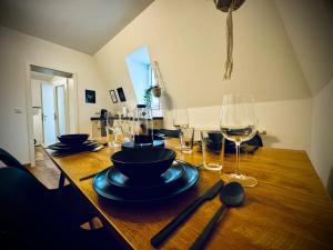 a wooden table with plates and wine glasses on it at One Apartment‘s / Steinweg / Neu in Coburg