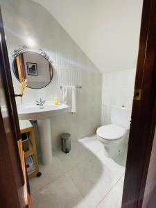 a white bathroom with a sink and a toilet at CASA PURI in Candeleda