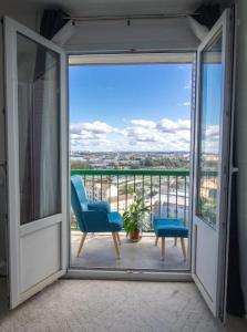 een balkon met een blauwe stoel en een raam bij Renovated 2-Bed Apartment 2 min from Lyon in Oullins