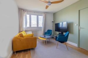 een woonkamer met een bank en stoelen en een tv bij Renovated 2-Bed Apartment 2 min from Lyon in Oullins
