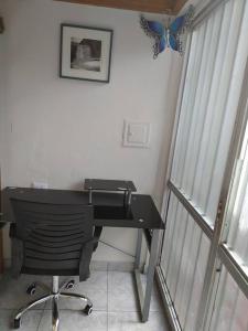 un escritorio en una habitación con una mariposa en la pared en hermoso mini departamento Miraflores a dos cuadras de Larcomar, en Lima