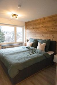 a bedroom with a large bed with a wooden wall at Spechthöhle - St. Georgen in Sankt Georgen im Schwarzwald