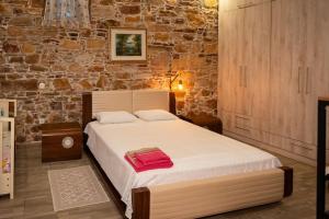 Un dormitorio con una cama con una toalla roja. en ΠΕΤΡΙΝΟ ΣΠΙΤΙ ΣΤΟΝ ΚΑΜΠΟ ΧΙΟΥ, en Chios
