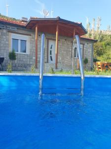 a swimming pool with blue water and two water slides at Rustic Villas Barlovic in Ulcinj