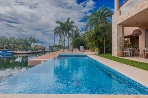 een zwembad voor een huis met een waterlichaam bij Marina 10 in Puerto Aventuras