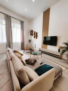ein Wohnzimmer mit einem großen Sofa und einem TV in der Unterkunft Beautiful apartments & Loft in Beziers center in Béziers