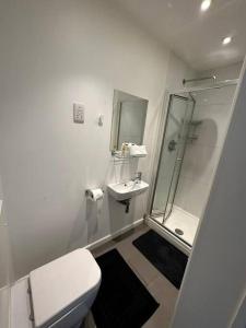 a white bathroom with a toilet and a sink at Sleep 6 Piccadilly Grand in London VR5 in London