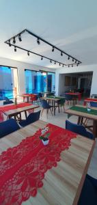 Hotel Da Orla في أراكاجو: غرفة مع طاولات وكراسي مع قماش الطاولة الحمراء