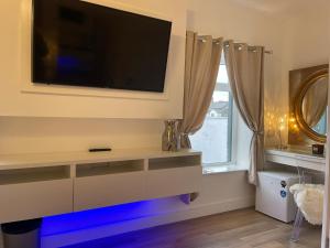 a living room with a flat screen tv on a wall at Vibrant Apartments Close to City Centre in Cardiff