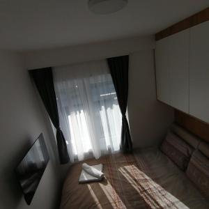 a small room with a bed with a window at Apartman Mali princ Jahorina in Jahorina