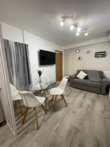 a living room with a couch and a table and chairs at Vistalegre! Coqueto apartamento junto al metro in Madrid